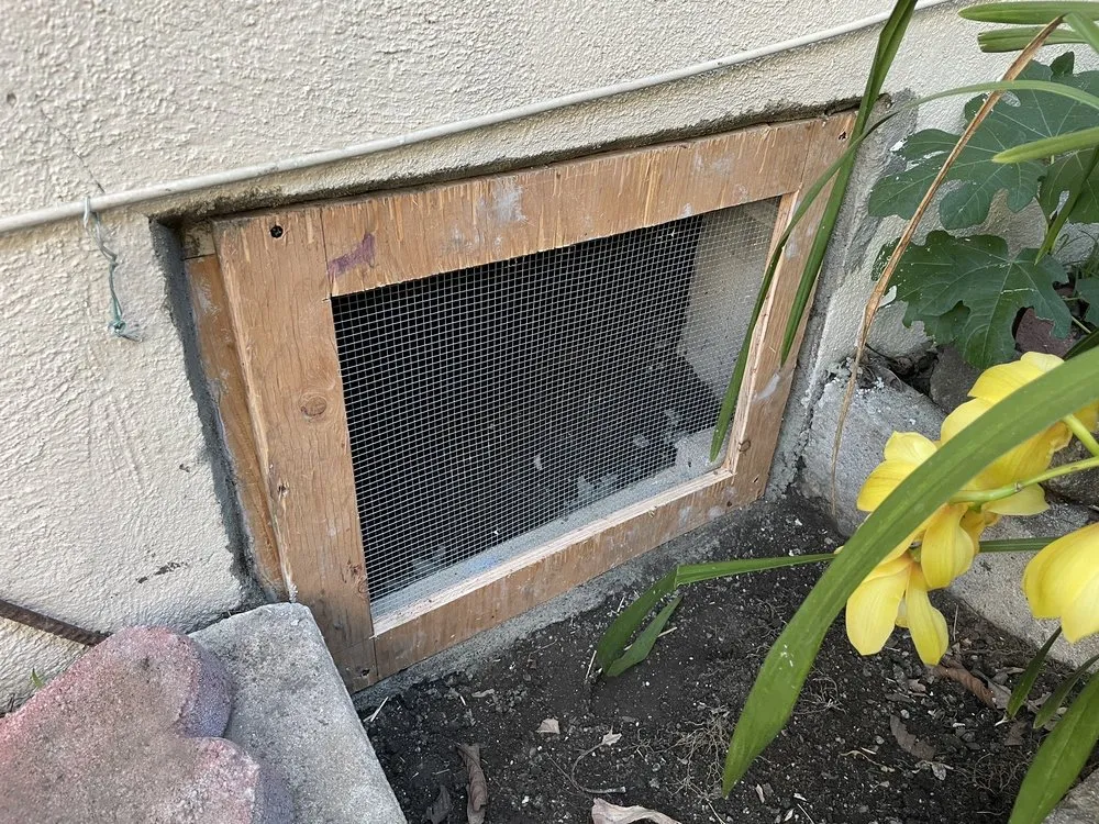 Crawlspace vent protected with a fitted metal screen